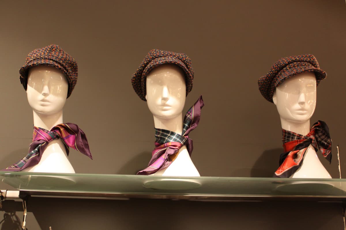 woman holding a vintage silk scarf inside a boutique